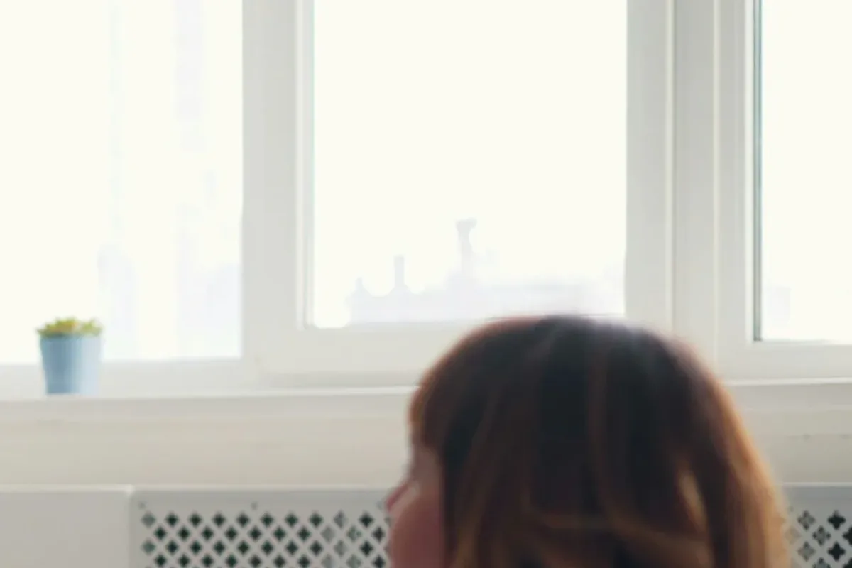 A young adult in India sitting across from a counsellor during a first therapy session, looking calmer and at ease.
