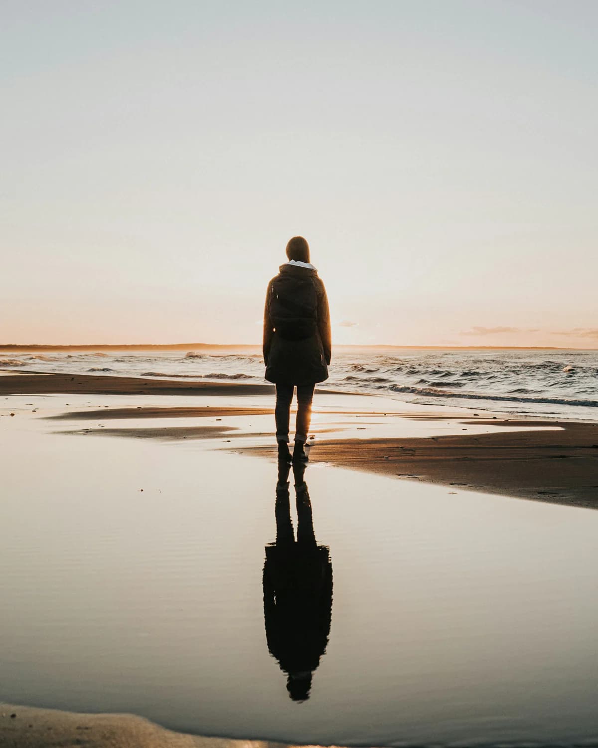 Person reflecting beside the sea