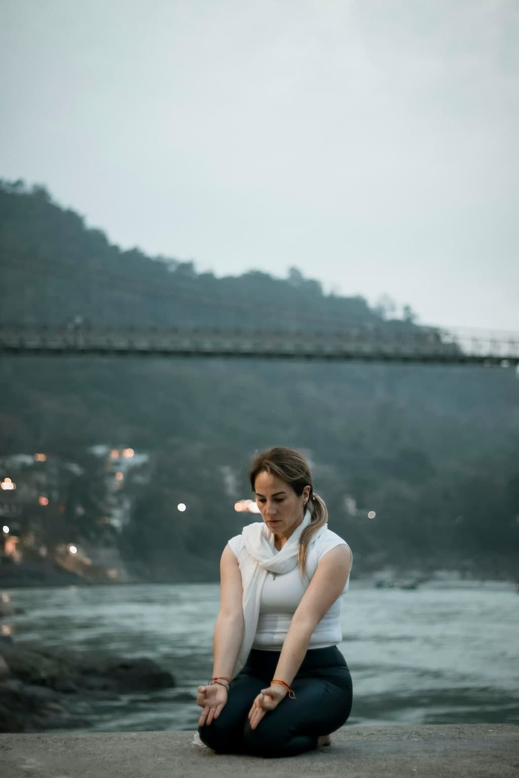 Woman pausing beside a lake in a quiet outdoor setting