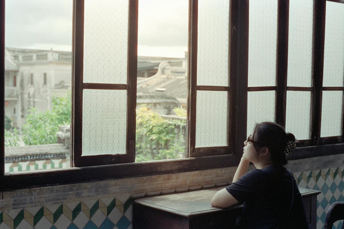 Woman sitting by a window in a quiet reflective moment