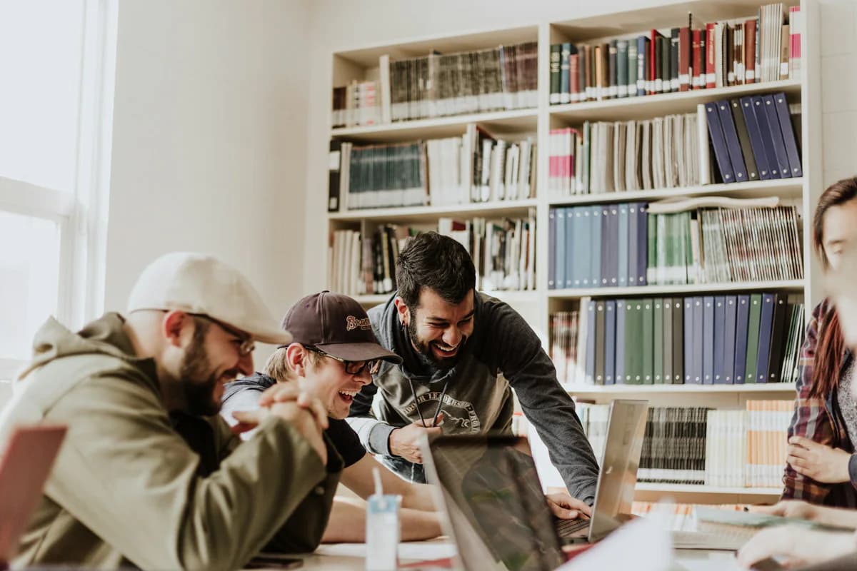 A group gathered around a laptop in a library