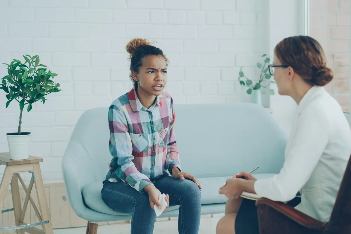 Two women talking while one takes notes