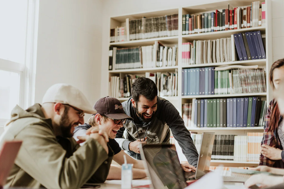 A group gathered around a laptop in a library