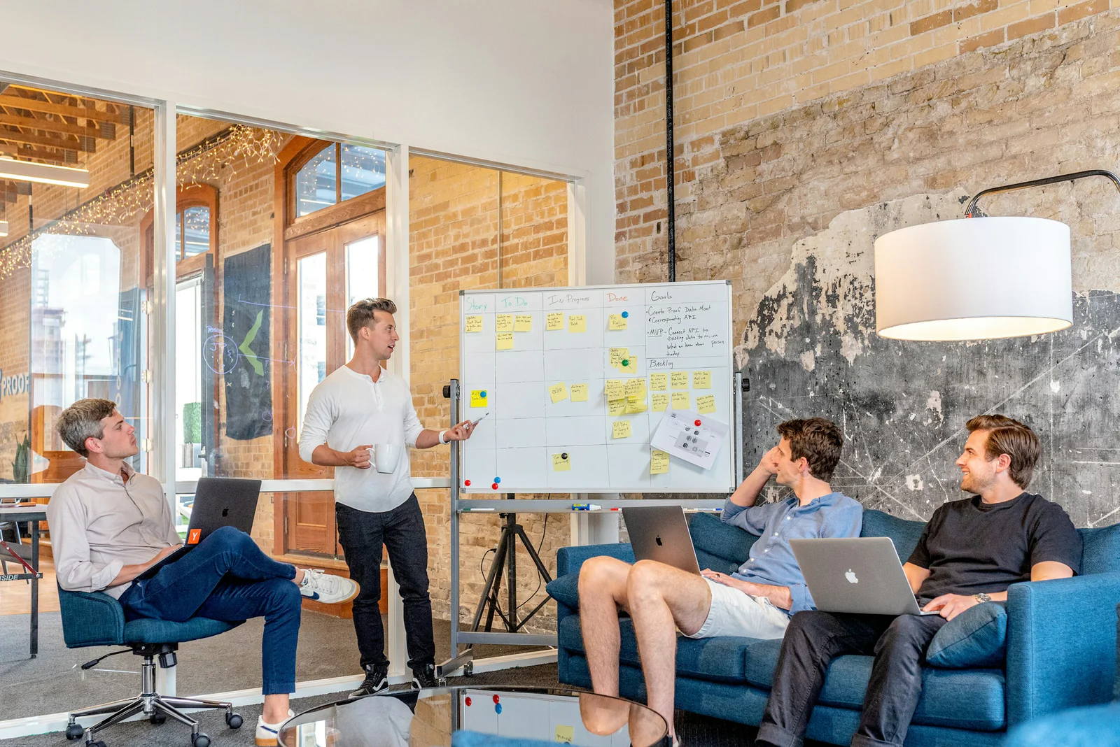 A presenter discusses a planning board with three colleagues