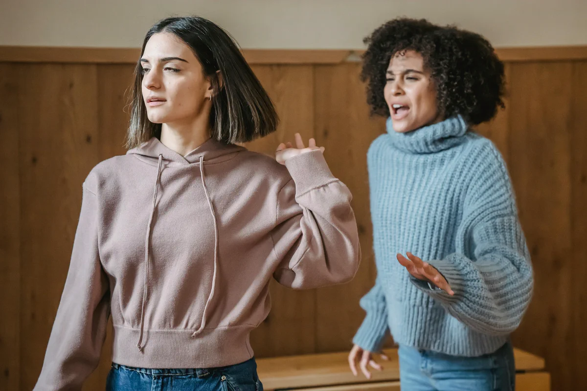 Two women turn away from each other during an argument