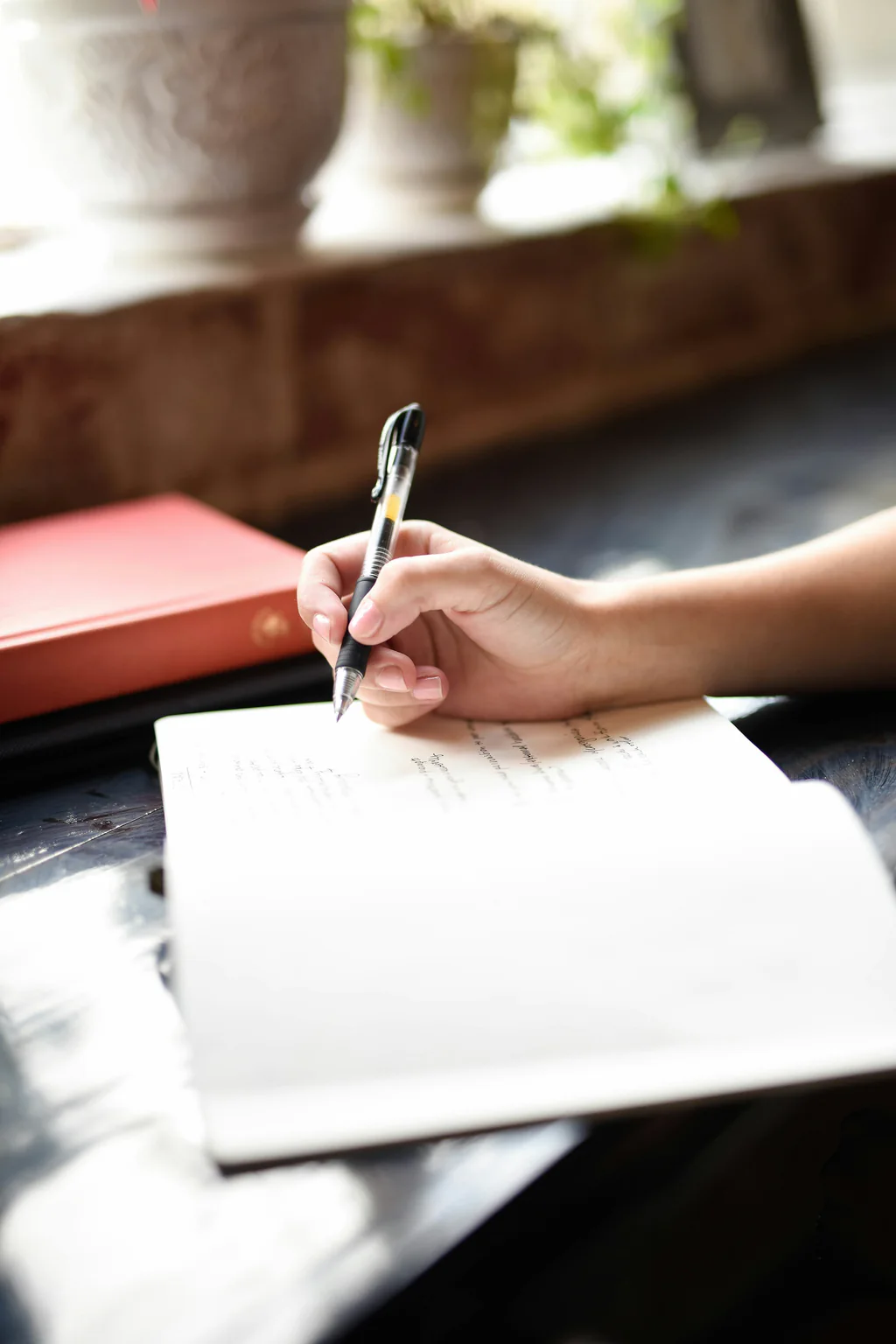 A hand writing notes in an open notebook