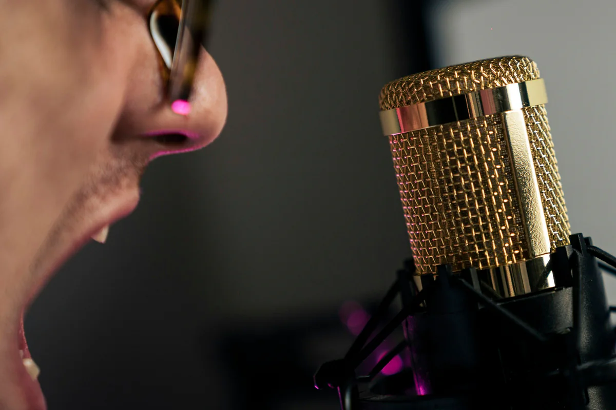 Close-up of a person speaking into a studio microphone