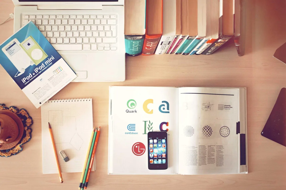 A tidy desk with a phone, notebook and pen