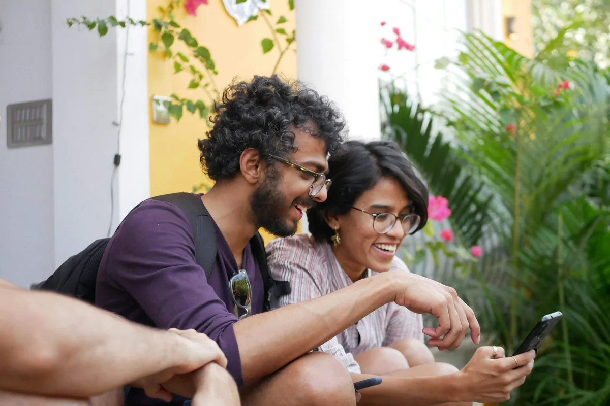 Two people looking at a phone together outdoors