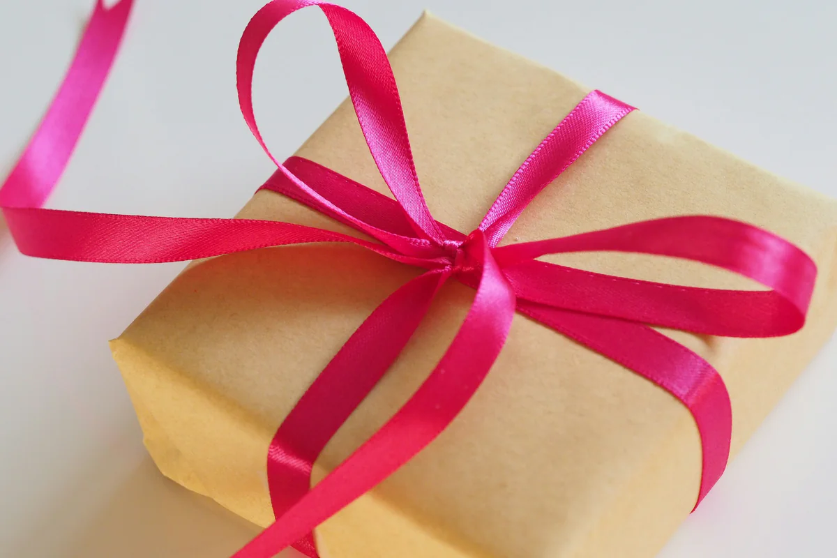 Wrapped kraft-paper gift tied with a pink ribbon